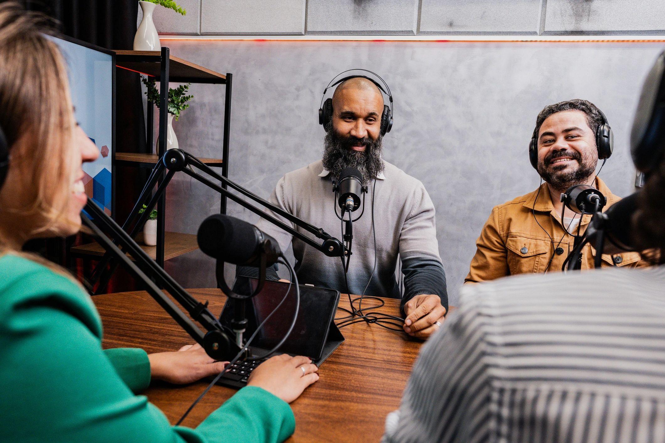 Podcast guests in discussion around microphones