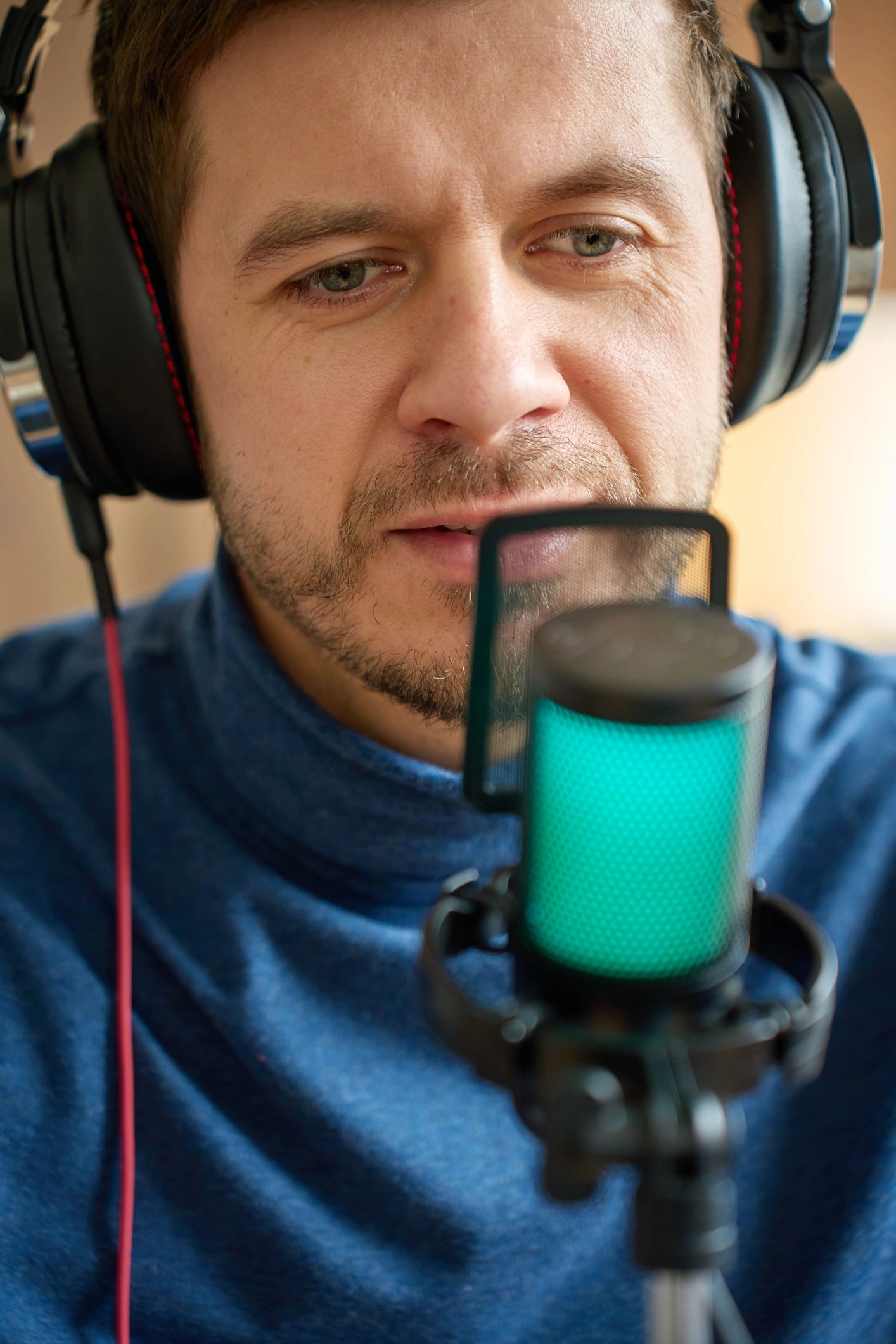 Podcast host speaking into a microphone with headphones on
